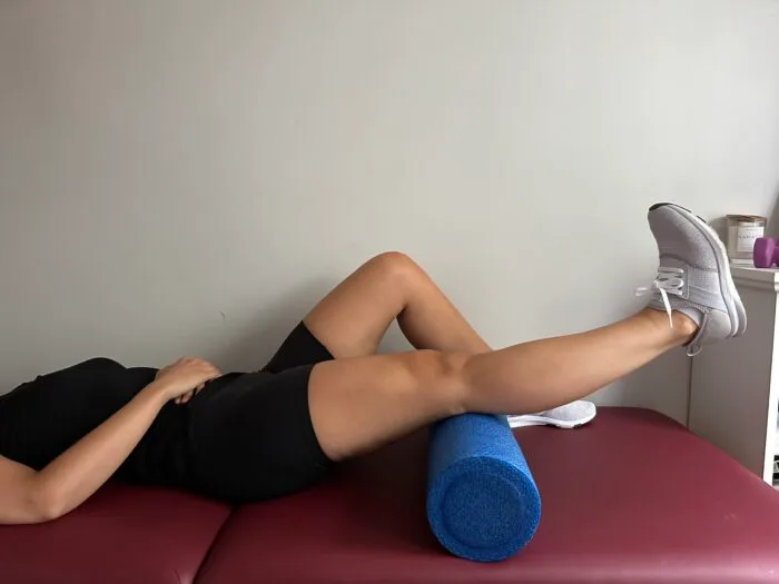 Demonstrating a short arc quad exercise to strengthen the quad muscle after a knee replacement.