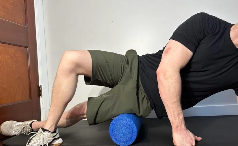 Me rolling out my IT band with a foam roller, lying on my side