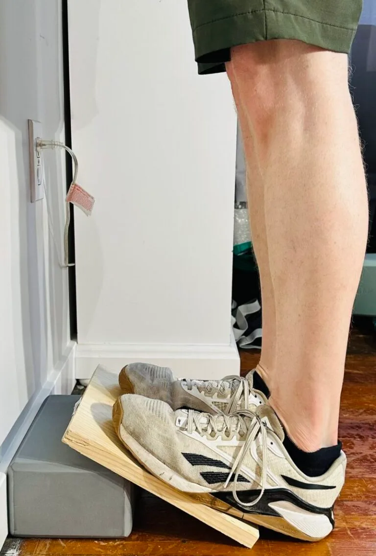 I'm demonstrating how to perform a gastroc calf stretch, standing on a slant board