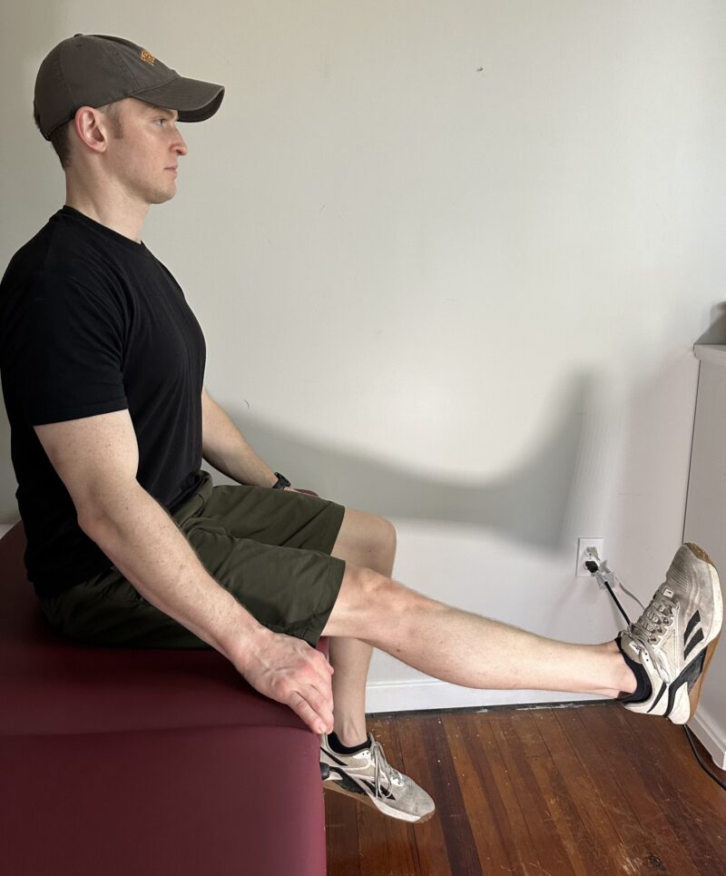 Leg extension exercise sitting on the edge of a massage table