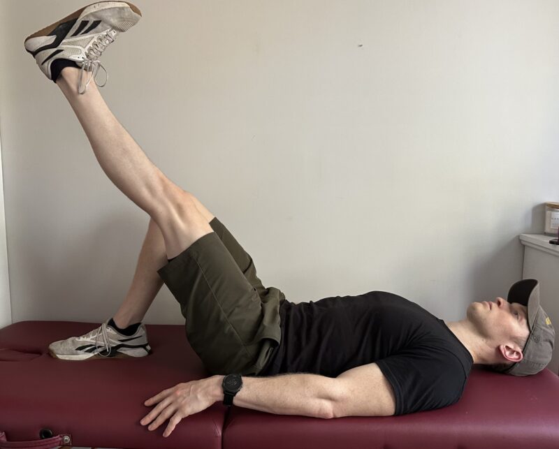 Demonstrating a straight leg raise exercise to strengthen the quadriceps after a knee replacement.