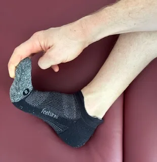 I'm demonstrating how to perform a plantar fascia stretch.