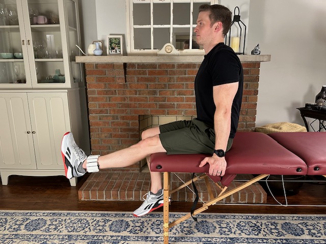 Demonstrating a long arc quad with an ankle weight as a quad strengthening exercise for a torn meniscus