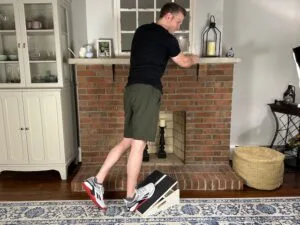 Demonstrating the best overall calf stretch on a slant board