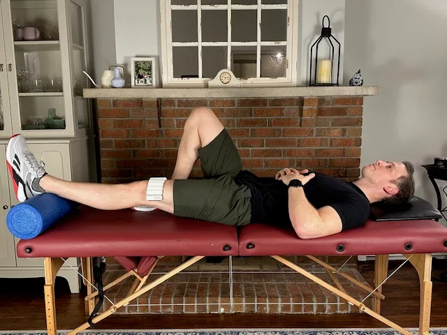 Demonstrating a heel prop with a weight exercise to increase knee extension after a knee replacement
