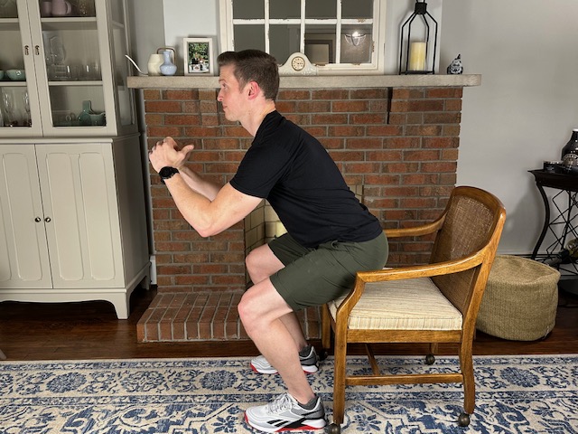 Demonstrating an eccentric squat to strengthen the quads, glutes, and patellar tendon