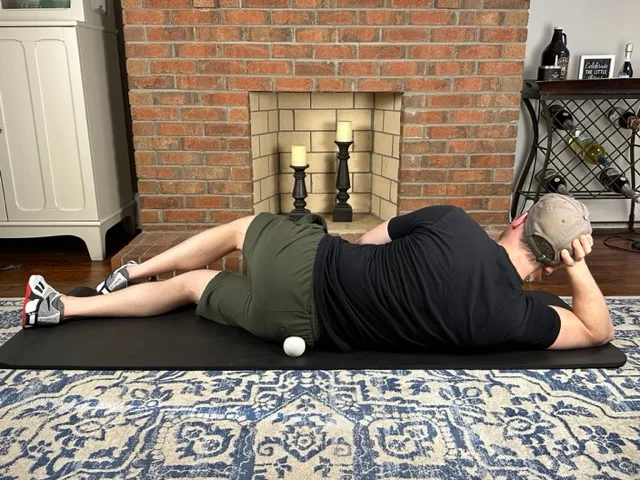 Demonstrating lacrosse ball mobilization to the gluteus medius muscle to treat gluteal tendinopathy