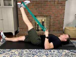 Demonstrating a hamstring stretch with a strap exercise to restore full knee extension before a knee replacement.