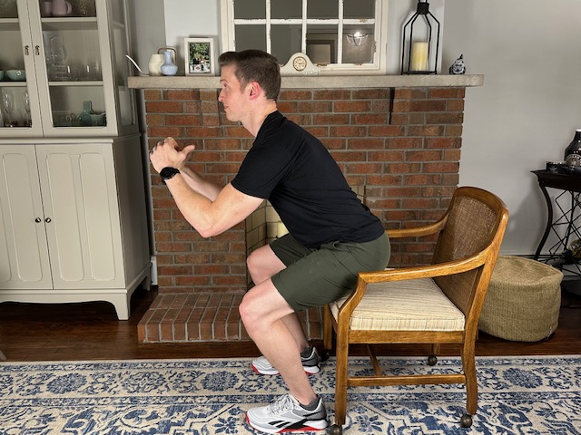 Demonstrating the squat to a chair exercise to increase leg strength before a knee replacement.