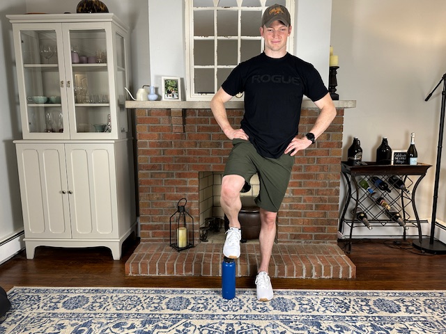 Demonstrating the cone step-over exercise to increase knee flexion and improve knee mobility