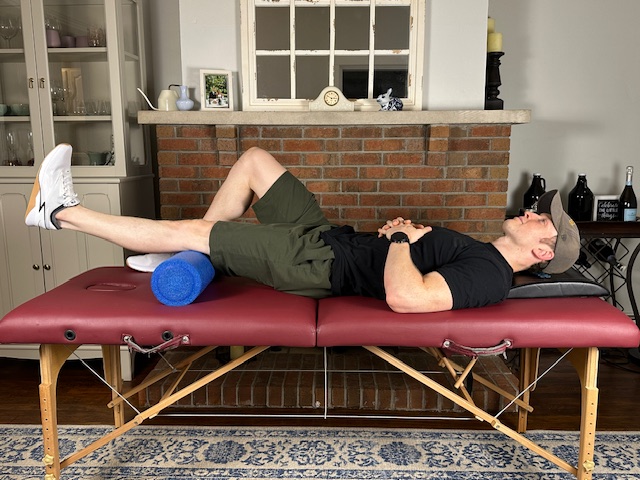 Demonstrating a short arc quad exercise to strengthen the quad muscle