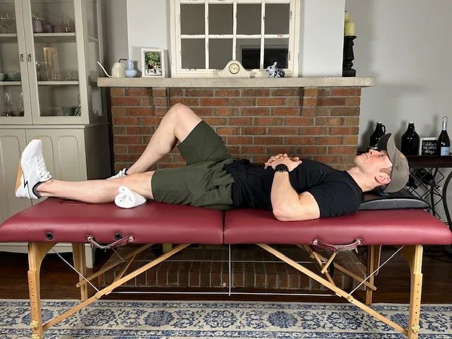 Physical therapist showing a quad set for early activation during osteochondral lesion recovery; no joint motion required