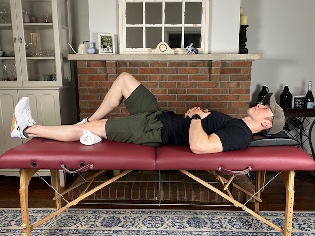 Quad set exercise with towel under knee to re-engage quadriceps muscle without moving the joint after ACL surgery