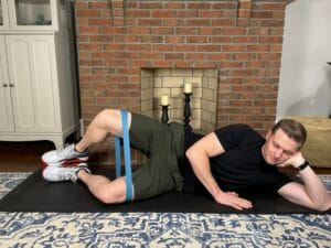 PT demonstrating sidelying clamshell exercise for glute activation and knee support during sitting